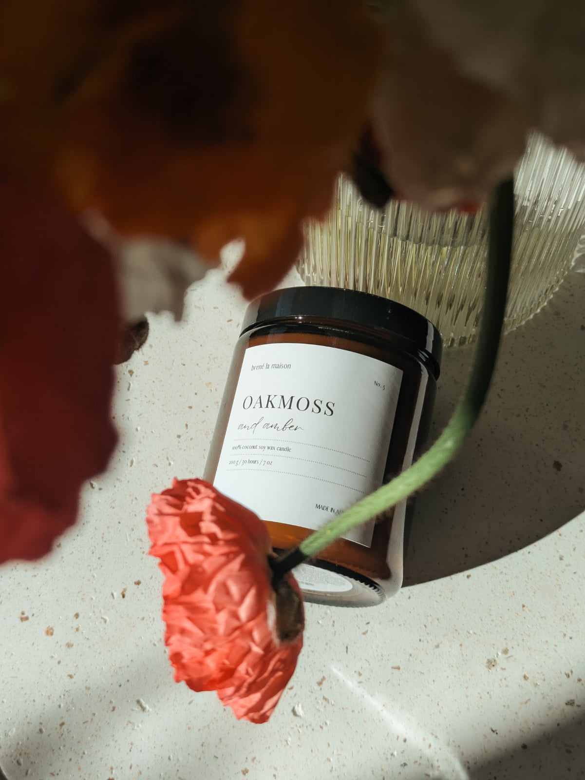 Oakmoss and Amber candle styled with poppy flower